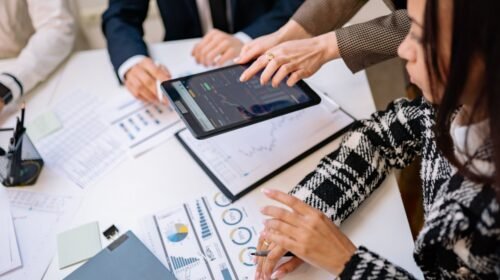 A group of analysts discussing Robinhood's zero-commission trading model in a modern office