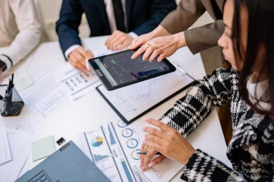A group of analysts discussing Robinhood's zero-commission trading model in a modern office