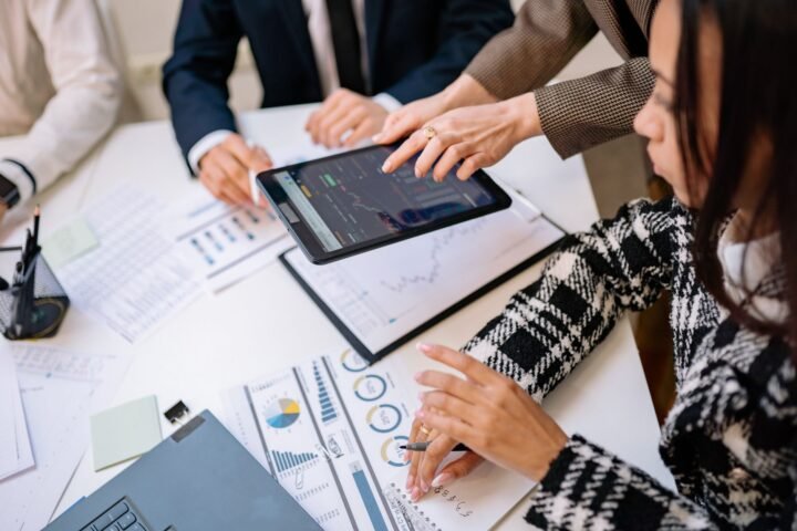 A group of analysts discussing Robinhood's zero-commission trading model in a modern office